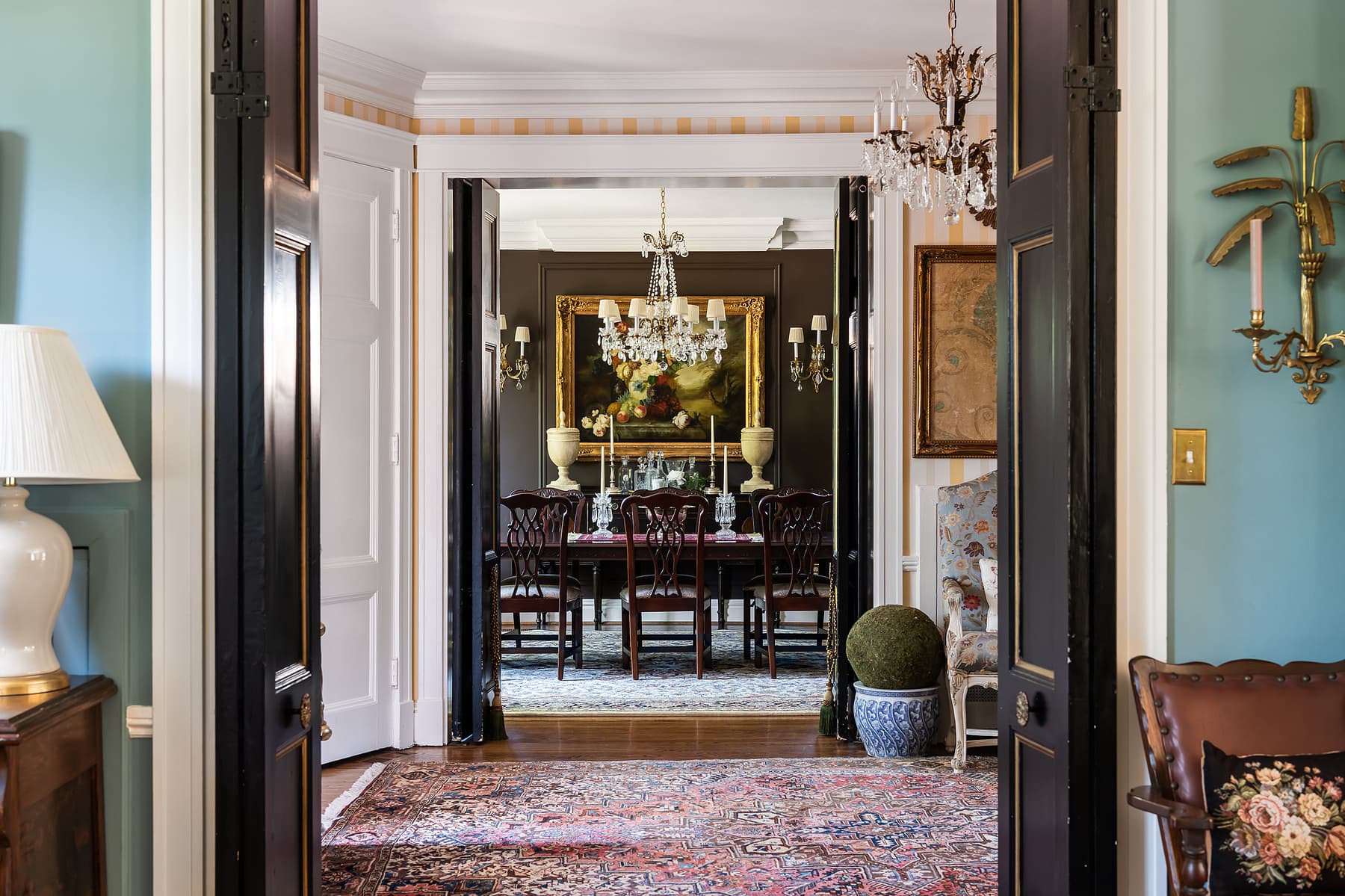Long interior hallway view with layered rooms, traditional furnishings, and chandelier creating depth in a classic residential design